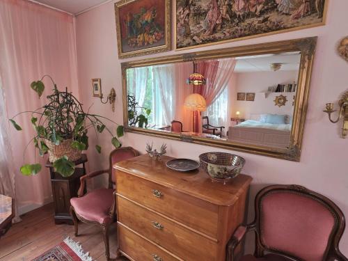 a room with a dresser and a mirror at Artist eremitage Leonora - Historic schoolhouse apartment in Fjälkinge