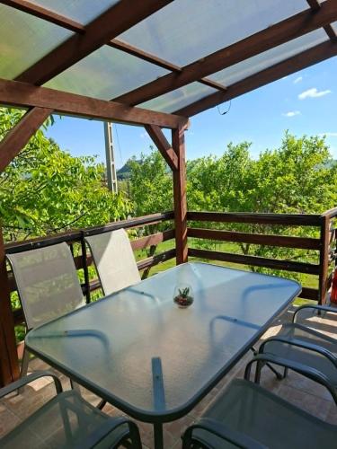 a table and chairs on a deck with a pergola at Panoráma Vendégház in Sümeg