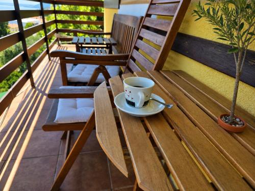 a cup of coffee sitting on a wooden table on a balcony at Apartments and Rooms Vila Irma in Opatija
