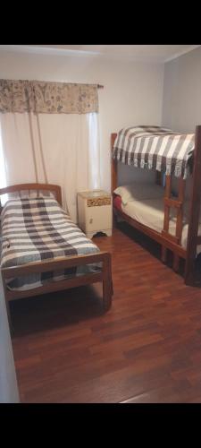 two bunk beds in a room with wooden floors at La quinta de Hostal in Rosario