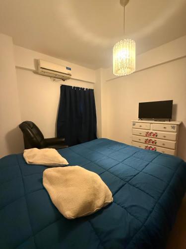 a bedroom with a blue bed with a chair and a dresser at General Acha 869 in San Juan