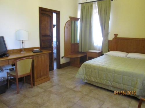 a bedroom with a bed and a desk and a computer at Relais Il Mulino in Corigliano Calabro