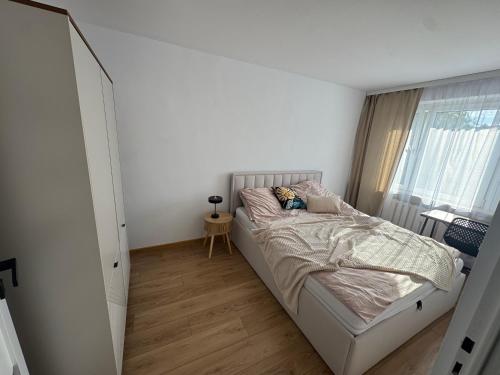 a small bedroom with a bed and a window at Apartament Blue Velvet in Skierniewice