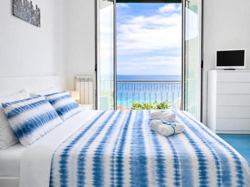 a teddy bear sitting on a bed in a bedroom at Vista Mare, Netflix & AC - Smeraldo Apartment in Laigueglia