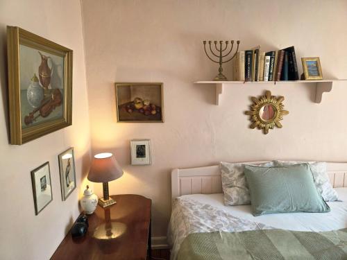 a bedroom with a bed and a table with a lamp at Artist eremitage Leonora - Historic schoolhouse apartment in Fjälkinge