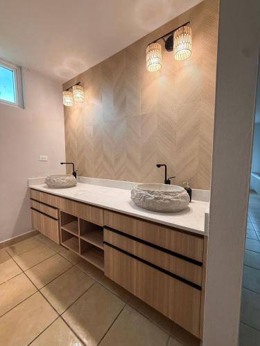 two sinks in a bathroom with two mirrors at Luxury Apartment with Ocean Views in Fajardo