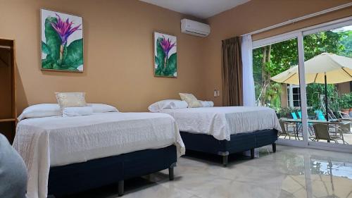two beds in a room with a view of a patio at Vidalta Hotel Boutique in Retalhuleu