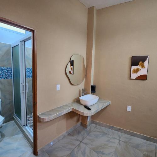 a bathroom with a sink and a mirror on the wall at Vidalta Hotel Boutique in Retalhuleu