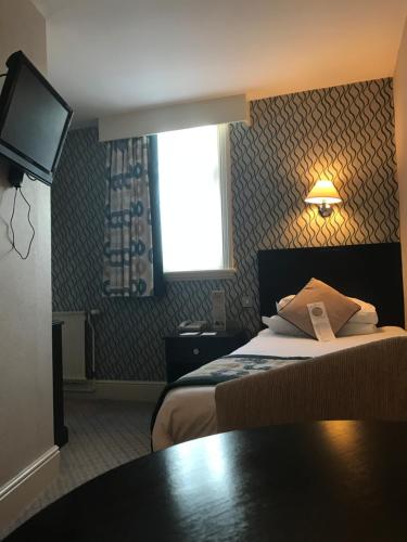 a hotel room with a bed and a television at Crown & Mitre Hotel in Carlisle