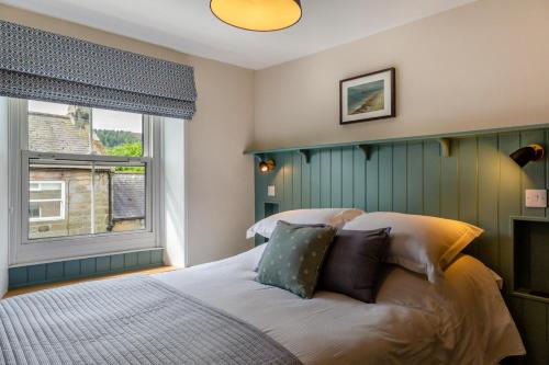 a bedroom with a bed with pillows and a window at 3 Bed in Morpeth oc-75083 in Harbottle