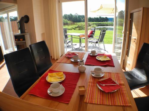 a wooden table with red napkins and dishes on it at Auszeit - Nordhorn in Nordhorn