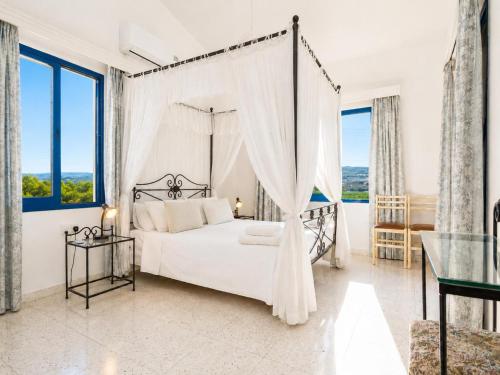 a bedroom with a canopy bed with a window at Villa Charoula Ena Large Private Pool AC WiFi in Polis Chrysochous