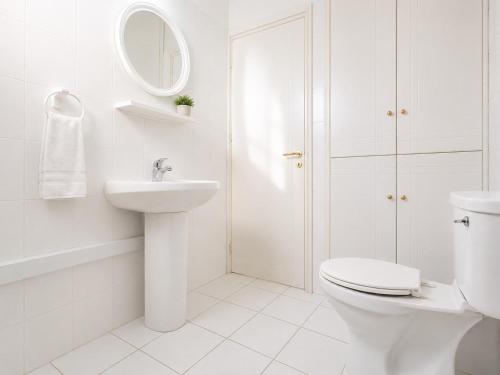 a white bathroom with a toilet and a sink at Villa Charoula Ena Large Private Pool AC WiFi in Polis Chrysochous