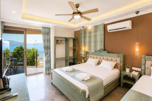 a bedroom with a bed with a ceiling fan and a balcony at Payam Agora Hotel Room Only , Shared Terrace & Kitchen in Kaş