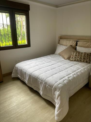 a large bed in a bedroom with two windows at El capricho de la Providencia in Gijón