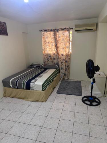a bedroom with a bed and a fan on a tiled floor at Mountain View Apartments in Gros Islet