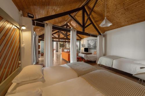 a bedroom with two beds and a living room at Flat 23 in Bombarral