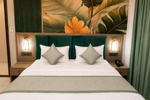 a bedroom with a bed with a green headboard and pillows at Hotel Heera Palace in Khātu