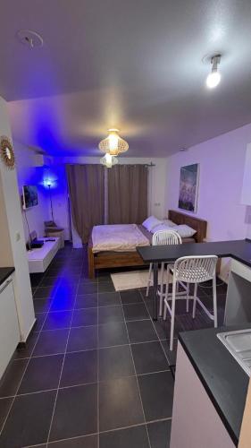 a room with a bed and a table and chairs at Studio à Sainte-Marie Studio Calme-Bord de mer avec Piscine in Sainte-Marie