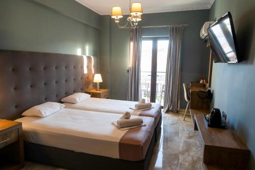 a bedroom with a large bed with towels on it at California Beach Hotel - Adults Only in Laganas