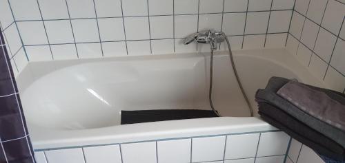 a white bath tub with a shower in a bathroom at Ferienwohnung in Walsrode