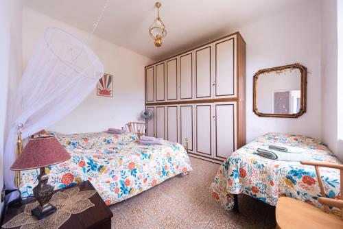 a bedroom with two beds and a mirror at Vita Lenta in Biassa