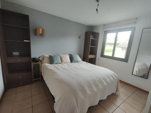 a bedroom with a white bed with a window at Los jardines de Osseja in Osséja