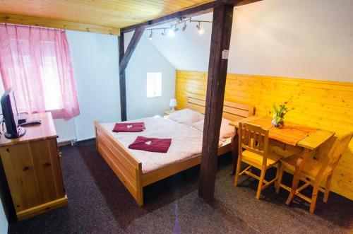 a bedroom with a bed and a table and a desk at Maxova Bouda in Josefŭv Dŭl