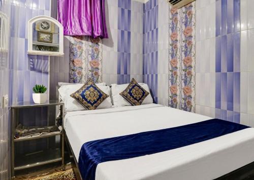 a bedroom with a bed with blue and white sheets at Hotel Amaravathi Residency in Guntūr