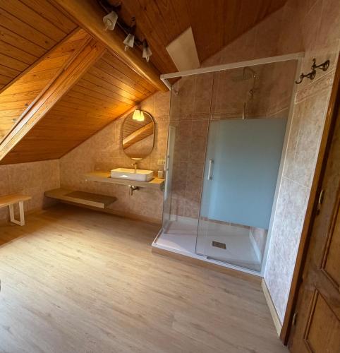 a bathroom with a glass shower and a sink at Cal Quimet in Rialp