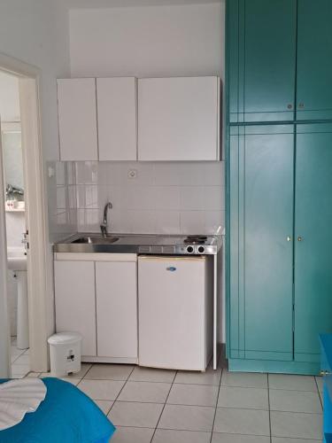 eine Küche mit weißen und blauen Schränken und einer Spüle in der Unterkunft Μeltemi in Glífa