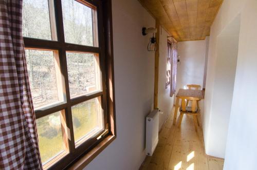 a hallway with two large windows and a wooden table at Maxova Bouda in Josefŭv Dŭl