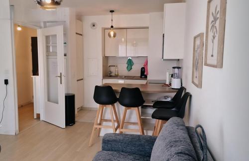a kitchen and living room with a couch and chairs at Paris Ouest Bezons Appartement entier in Bezons