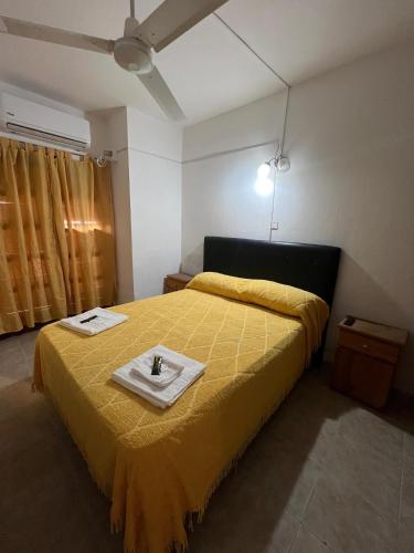 a bedroom with a yellow bed with a tray on it at HSR Termas in Termas de Río Hondo