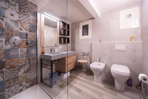 a bathroom with a toilet and a sink and a shower at Vita Lenta in Biassa