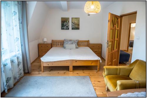 a small bedroom with a bed and a chair at Mazury- dom wakacyjny in Pisz