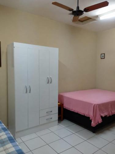 a bedroom with a white cabinet with a pink bed at Cantinho do Sossego in Indaiatuba