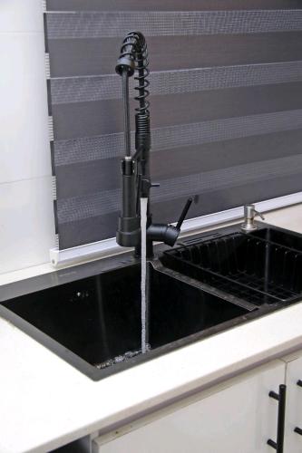 a kitchen sink with water running from a faucet at 2 bedroom Apartment Lekki Ovation Terrace and extra room in Lekki