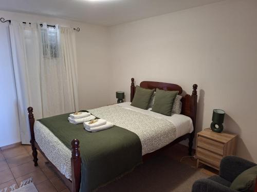 a bedroom with a bed with two towels on it at Pôr do Sol in Estreito da Calheta