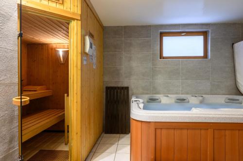 a bathroom with a bath tub in a room at Chalet Les Genêts 2 - Spa et Sauna in Saint-Amarin
