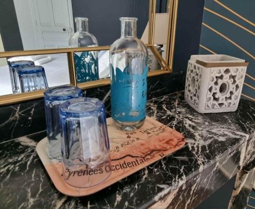 a counter with two glass jars and a bottle on it at Le Logis de Placide in Tarbes