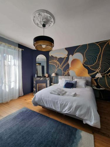a bedroom with a large bed and a large mirror at Le Logis de Placide in Tarbes