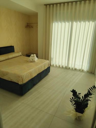 a bedroom with a bed and a plant in it at AnnAmuri in Belpasso
