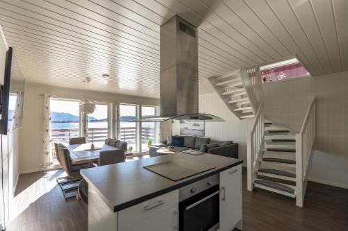 a kitchen and living room with a staircase in a house at Lofoten Rorbu Lodge in Offersøya
