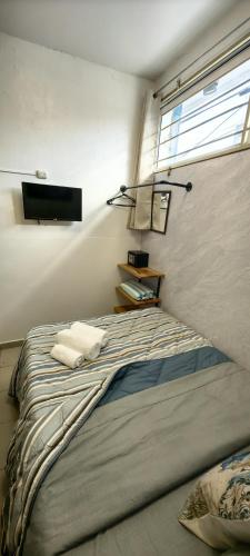 a bedroom with a large bed with a window at Loft #1 a una cuadra de Playa Regatas Oyster Suites in Veracruz
