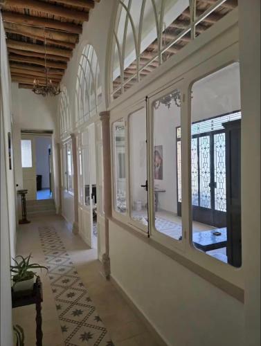 a hallway of a house with windows and a table at LoCanda - Blat in Zahlé