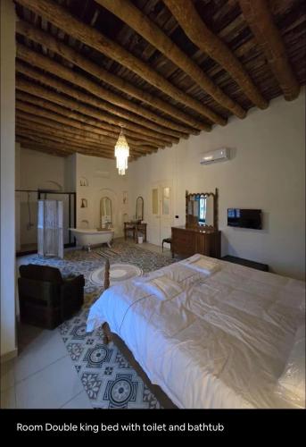 a bedroom with a large bed with toilet and bathtub at LoCanda - Blat in Zahlé