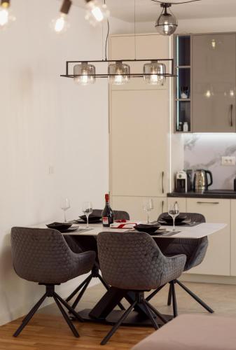 a dining room table with two chairs and a table with wine glasses at Vujicic Premium Suite in Tivat