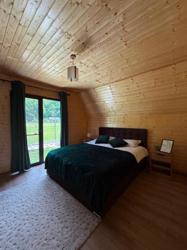 a bedroom with a large bed in a wooden room at LaMonte Retreat in Brezoi