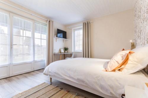 a bedroom with a bed and a large window at Le Bois aux Cerfs in Bois-Jérôme-Saint-Ouen